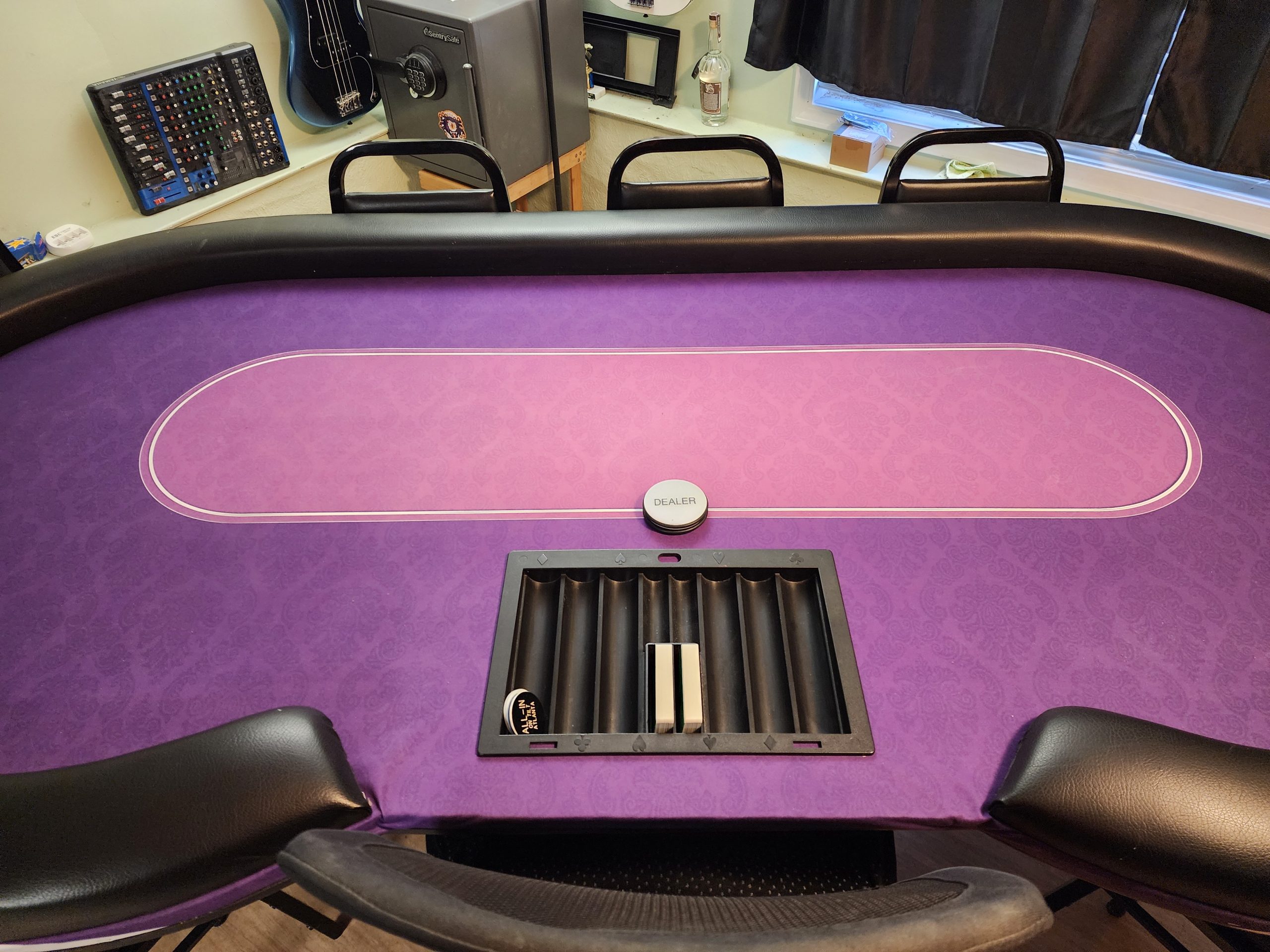 An oval poker table with a dealer cut out covered in purple felt.